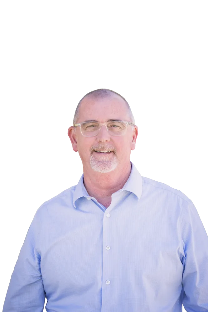 Smiling bald man with glasses and a gray goatee wearing a light blue button-down shirt