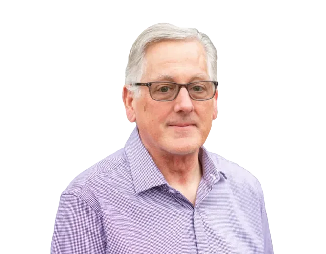 Gray-haired man wearing glasses and a purple button-down shirt