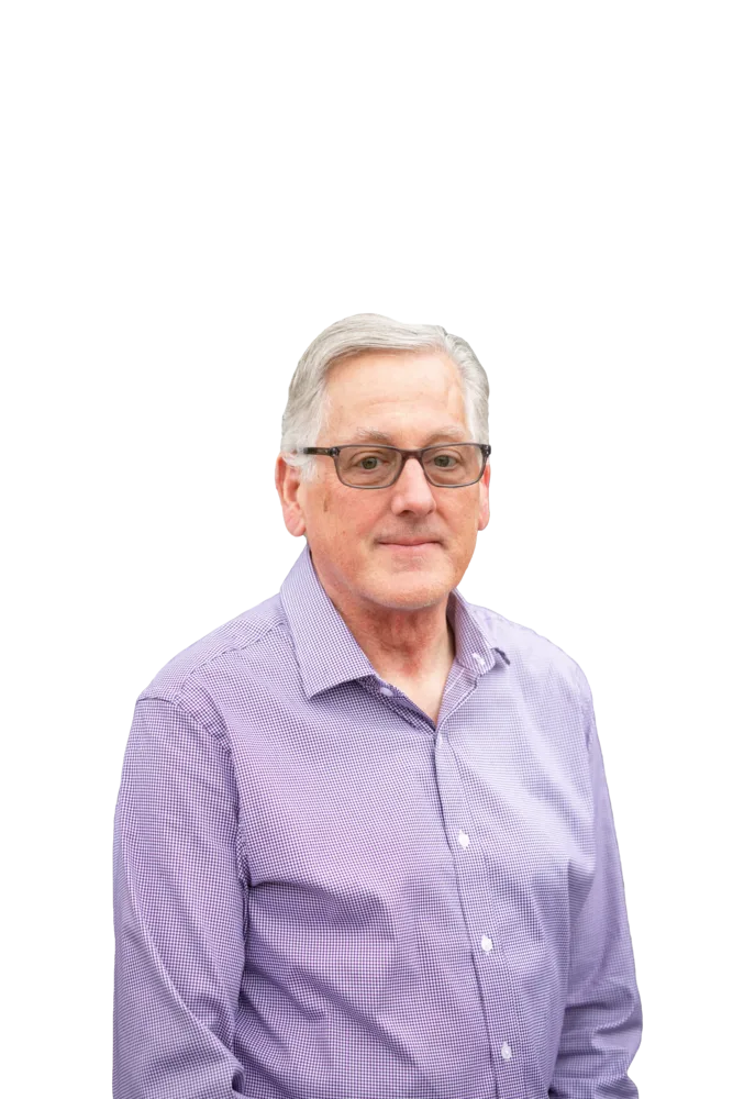 Gray-haired man wearing glasses and a purple button-down shirt