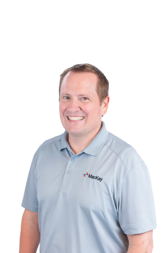 Smiling man wearing a light blue Mackay polo shirt