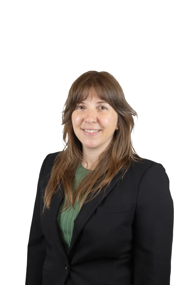 Smiling woman with long brown hair wearing a black blazer and green top