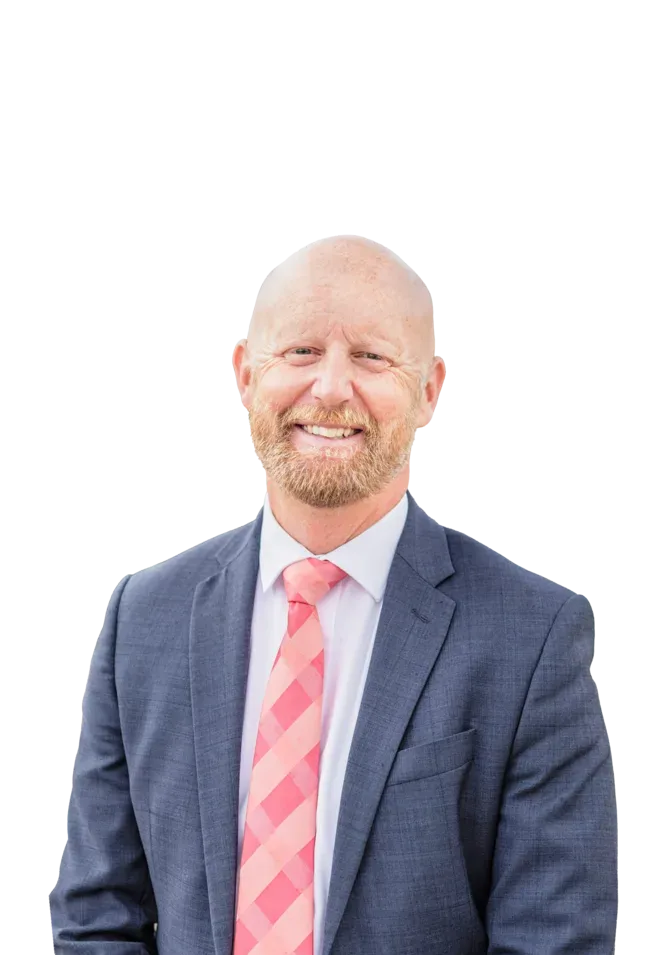 Smiling bald man with a beard wearing a blue suit, white shirt, and pink striped tie