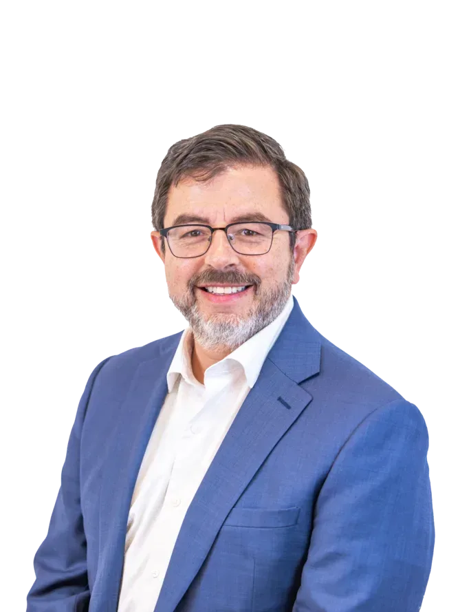 Smiling bearded man wearing glasses, a blue suit, and white shirt