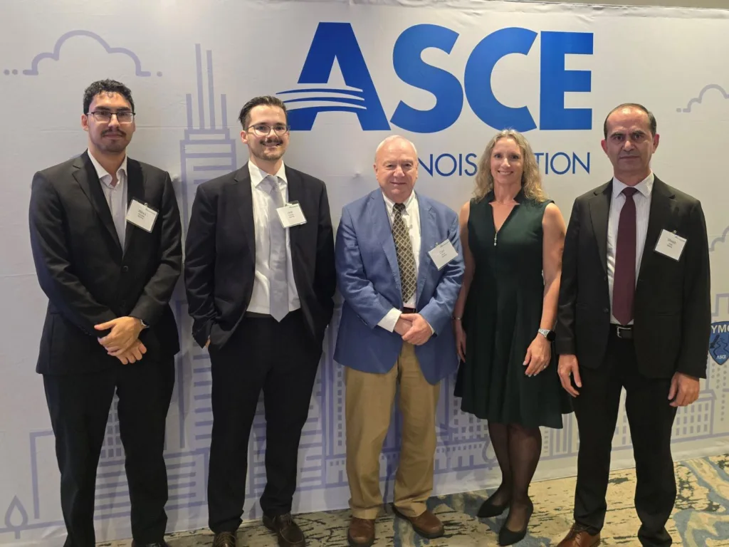 Five formally dressed people pose in front of an ASCE Illinois Section backdrop