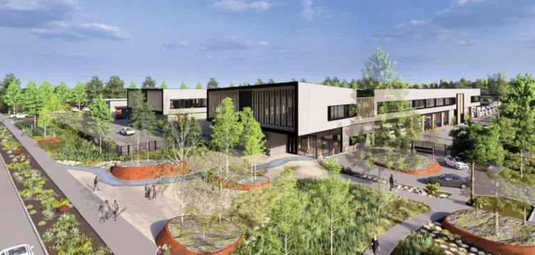 Architectural rendering of a modern two‑story commercial campus with long rectangular buildings, large windows, parking areas, and landscaped pedestrian paths with trees and raised planters under a blue sky.