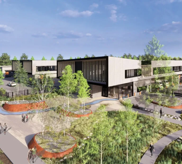 Architectural rendering of a modern two‑story commercial campus with long rectangular buildings, large windows, parking areas, and landscaped pedestrian paths with trees and raised planters under a blue sky.