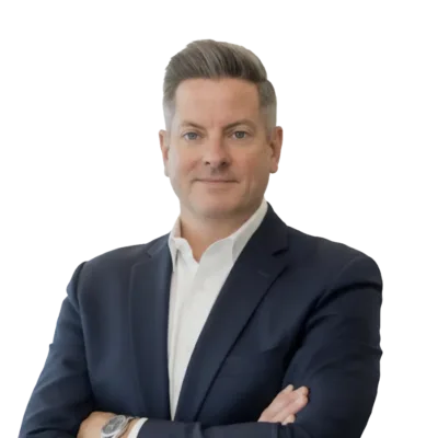 Professional headshot of a man in a navy suit and white shirt with his arms crossed