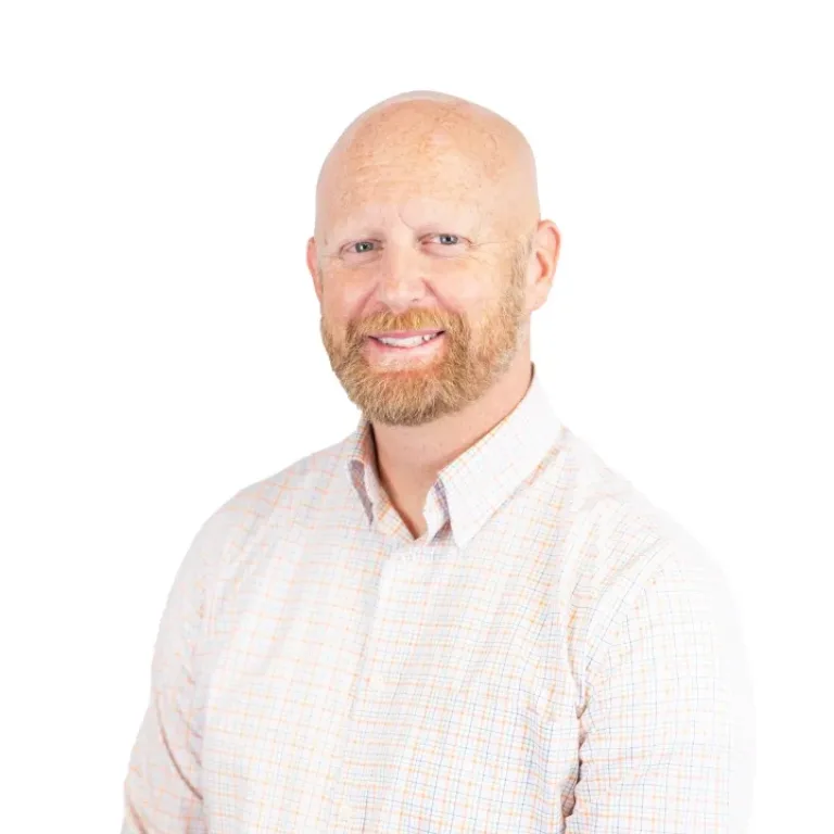 Smiling bald man with a reddish beard wearing a light plaid button-down shirt