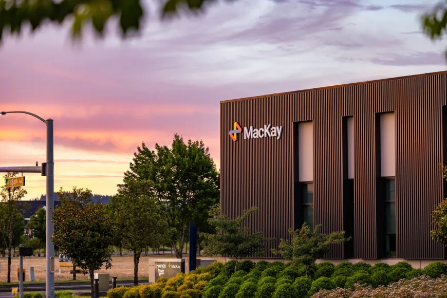 Mackay building on 184th Avenue at sunset, with landscaped grounds and street signs for Holman Road and Bennington Drive