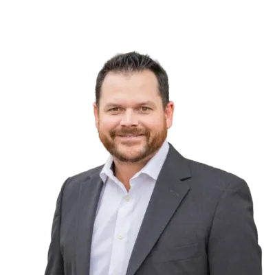 Smiling bearded man wearing a dark suit jacket and white collared shirt