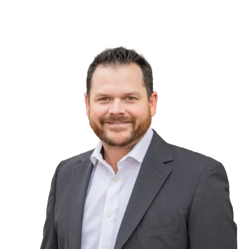 Smiling bearded man wearing a dark suit jacket and white collared shirt