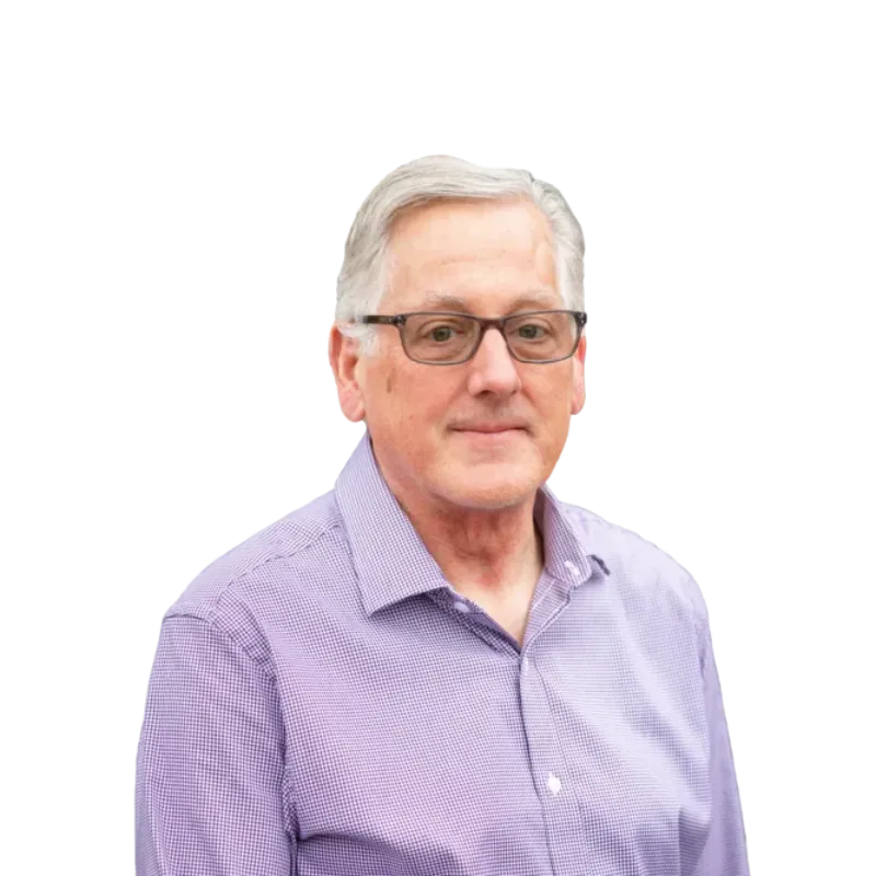 Gray-haired man wearing glasses and a purple button-down shirt