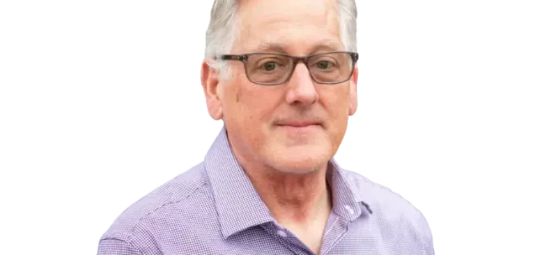 Gray-haired man wearing glasses and a purple button-down shirt