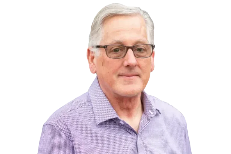 Gray-haired man wearing glasses and a purple button-down shirt