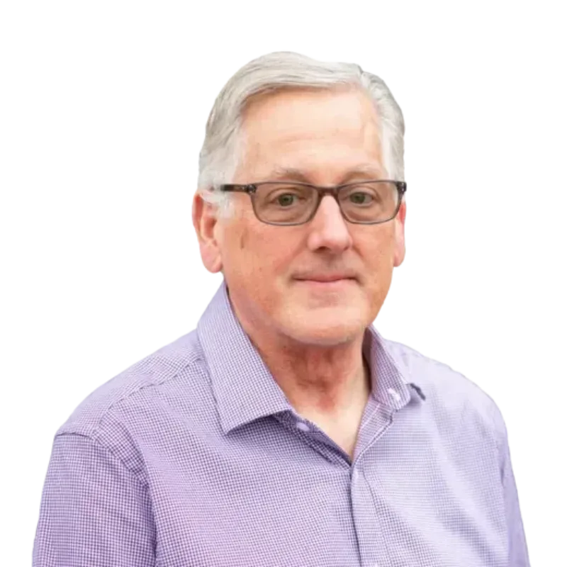 Gray-haired man wearing glasses and a purple button-down shirt