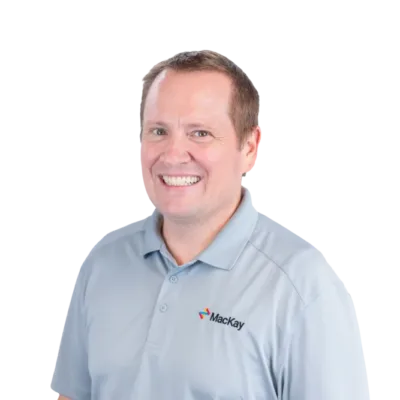 Smiling man wearing a light blue Mackay polo shirt