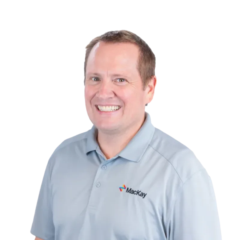 Smiling man wearing a light blue Mackay polo shirt