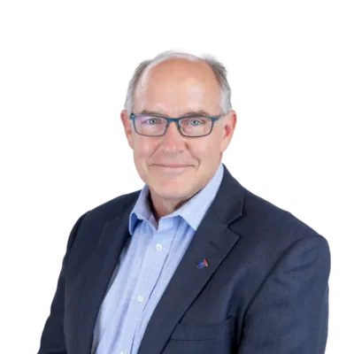 Middle-aged man wearing glasses, a navy blazer, and a light blue shirt