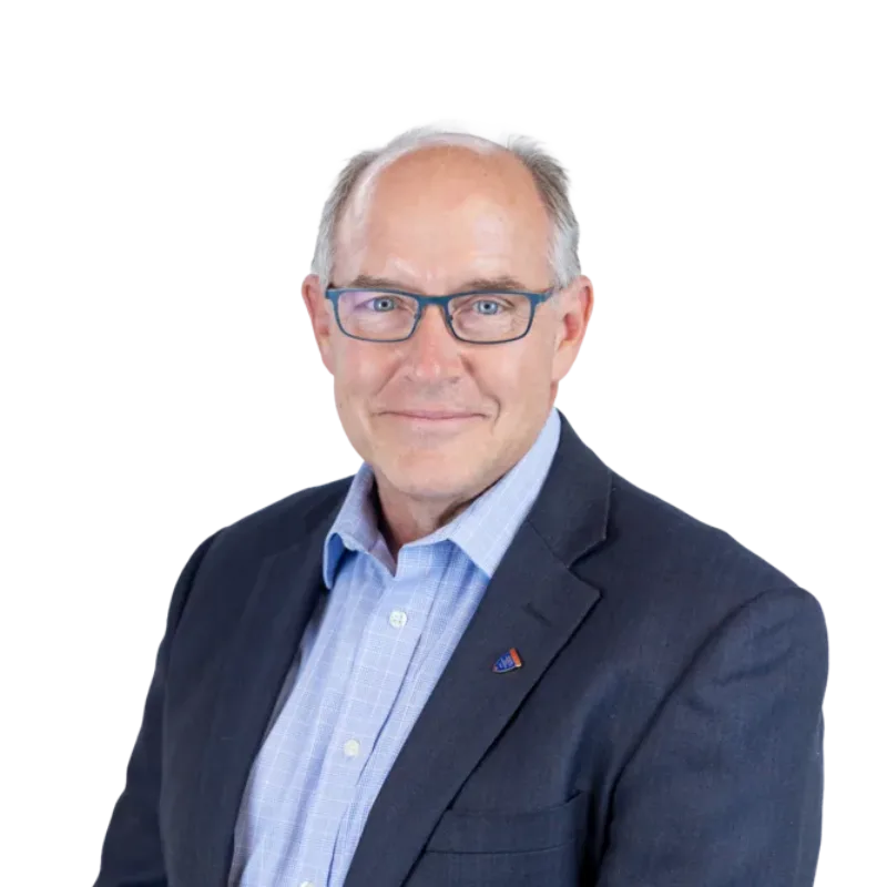 Middle-aged man wearing glasses, a navy blazer, and a light blue shirt