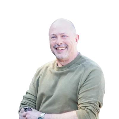 Smiling bald man in a green sweatshirt with folded arms