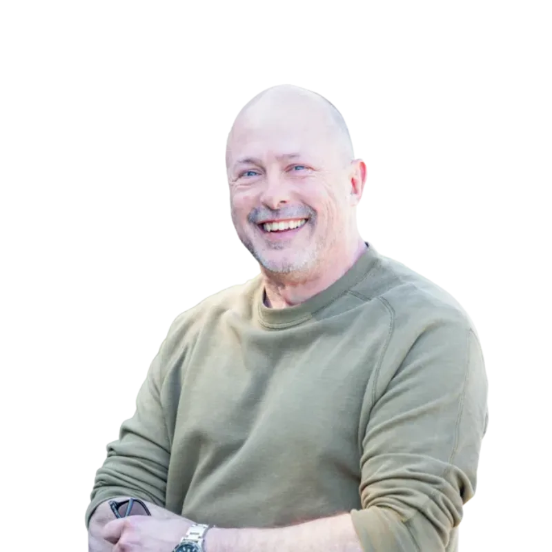 Smiling bald man in a green sweatshirt with folded arms