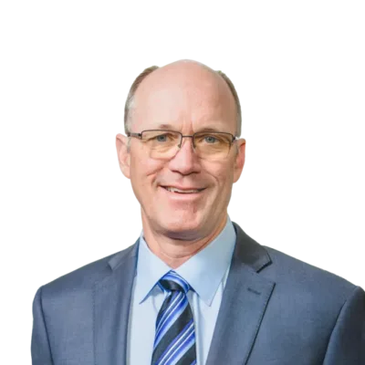 Man wearing glasses, a blue suit, and striped tie, smiling at the camera
