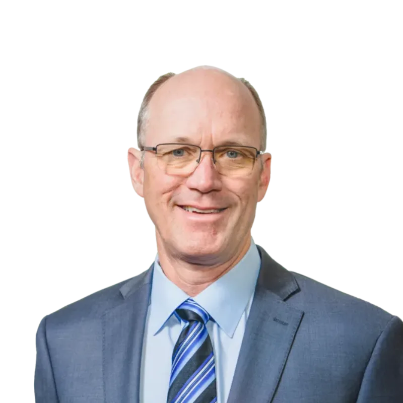 Man wearing glasses, a blue suit, and striped tie, smiling at the camera