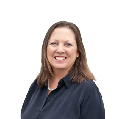 Smiling woman with shoulder-length brown hair wearing a dark blouse and pearl necklace