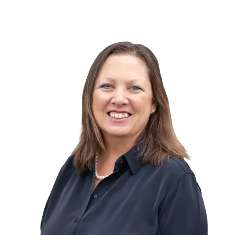 Smiling woman with shoulder-length brown hair wearing a dark blouse and pearl necklace