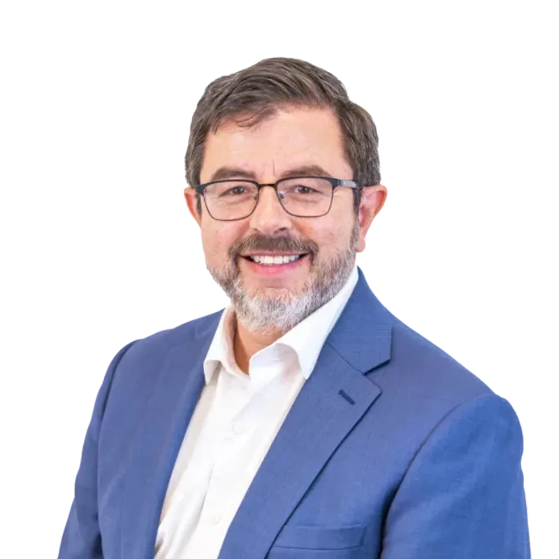 Smiling bearded man wearing glasses, a blue suit, and white shirt