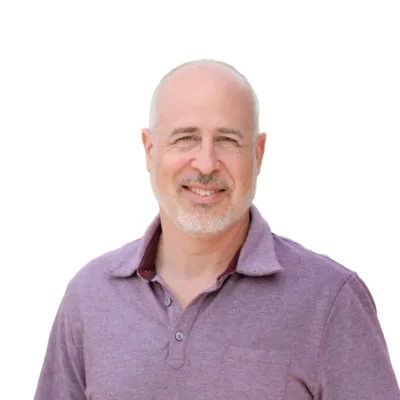 Smiling bald man with a gray goatee wearing a purple polo shirt