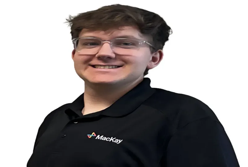 Smiling person wearing glasses and a black Mackay polo shirt